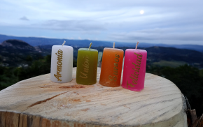 Cuatro velas cuadradas de colores con palabras grabadas: Armonía, Gratitud, Prosperidad y Amor