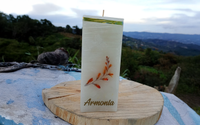 Vela cuadrada blanca con grabado “Armonía” sobre fondo natural