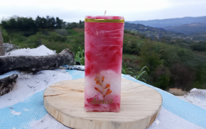 Vela cuadrada roja con detalles florales y acabado artesanal