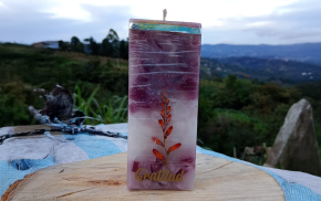 Vela cuadrada morada con grabado “Gratitud” y fondo de paisaje natural