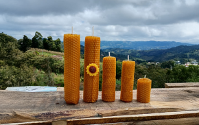 Conjunto de velas de cera de abeja natural sobre fondo montañoso